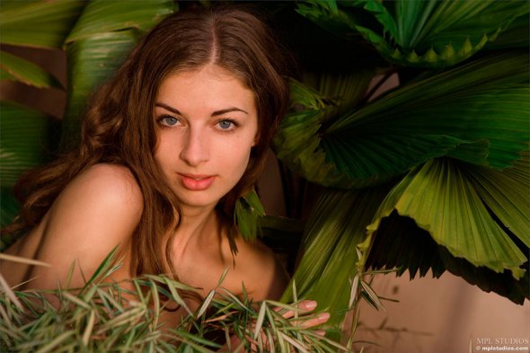 Голая девушка среди тропических растений